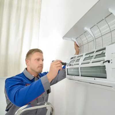 HVAC technician working on system